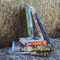 Stack of childrens farming books on top of hay bale